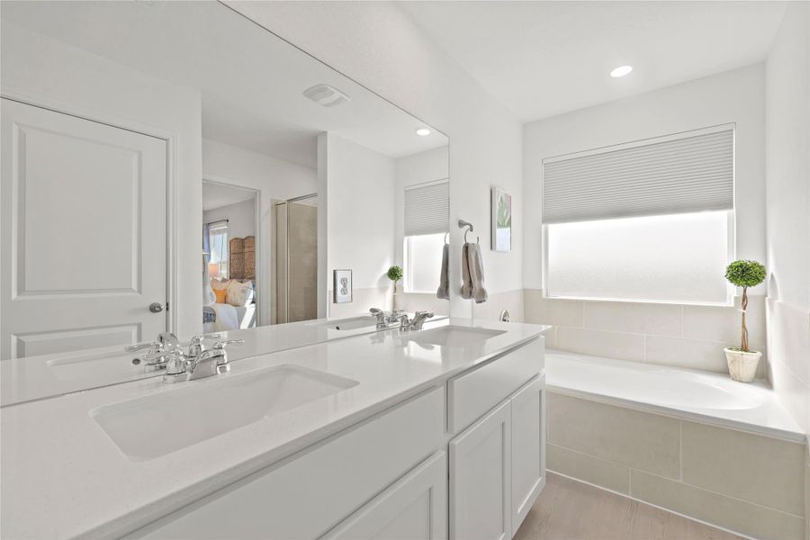 Full bath featuring ensuite bathroom, double vanity, a bath, a stall shower, and recessed lighting
