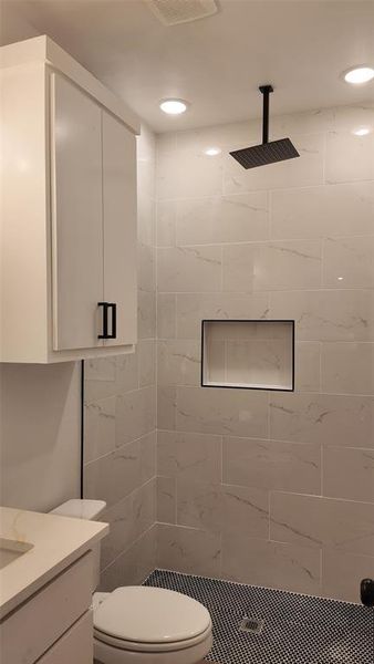 Full bathroom featuring tiled shower and vanity Full bathroom featuring tiled shower and vanity