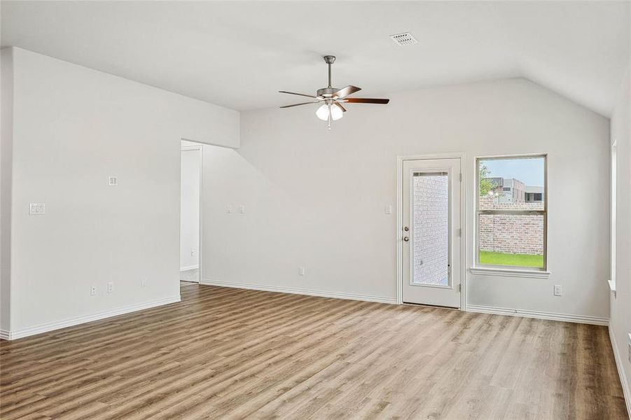 Unfurnished room featuring ceiling fan, vaulted ceiling, and light hardwood / wood-style flooring