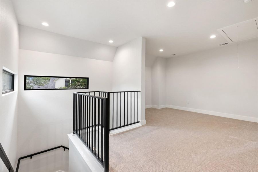 An airy upstairs area awaits, boasting plush carpeting and modern recessed lighting.