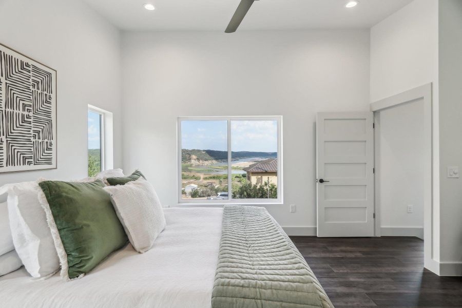 Bedroom with wood finished floors, a towering ceiling, recessed lighting, a ceiling fan, and baseboards Bedroom with wood finished floors, a towering ceiling, recessed lighting, a ceiling fan, and baseboards