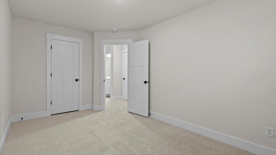 Accomplished design shines in this carpeted bedroom with a functional walk-in closet