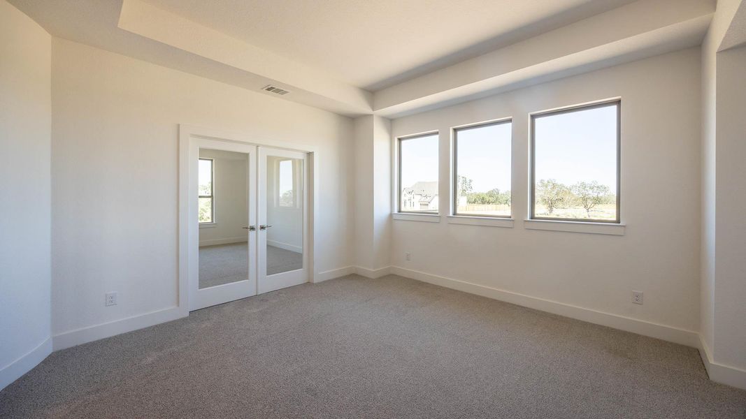 Unfurnished room featuring light carpet, french doors, and a raised ceiling Unfurnished room featuring light carpet, french doors, and a raised ceiling