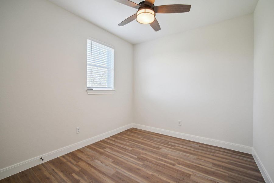 Bedroom 2 featuring baseboards, ceiling fan, and wood finished floors Bedroom 2 featuring baseboards, ceiling fan, and wood finished floors