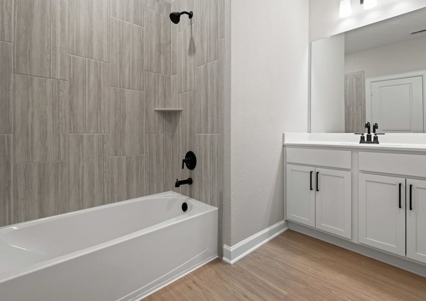 Spacious vanity and tub/shower combination with tile detail in the second bathroom