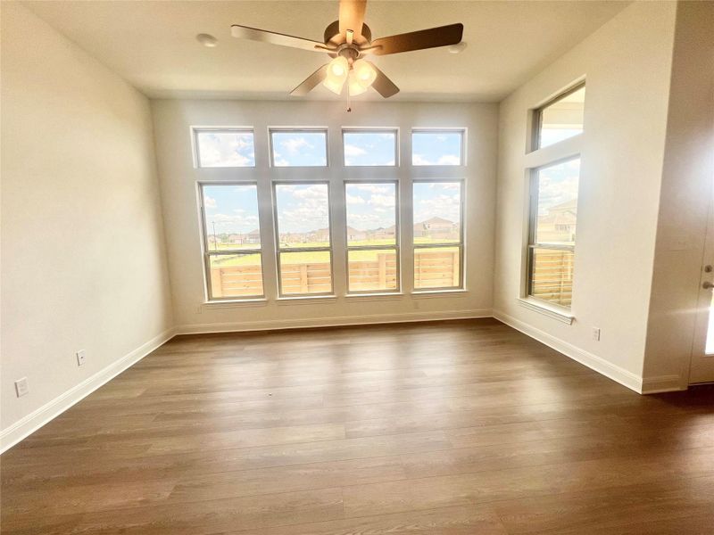Spare room with dark wood-style floors and a ceiling fan Spare room with dark wood-style floors and a ceiling fan