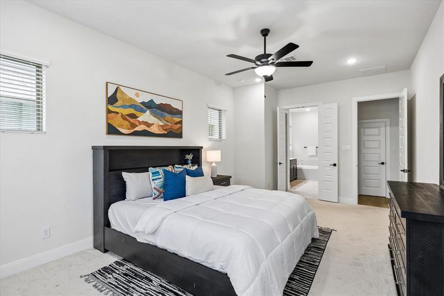 Bedroom with neutral-toned carpeting, a ceiling fan with integrated lighting, and recessed overhead lighting Bedroom with neutral-toned carpeting, a ceiling fan with integrated lighting, and recessed overhead lighting