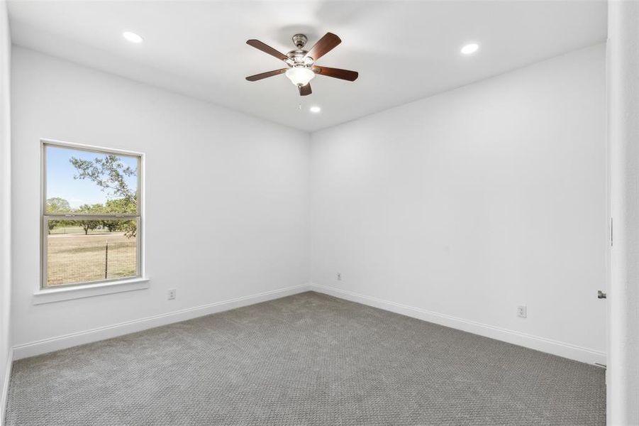 Spare room featuring ceiling fan and carpet