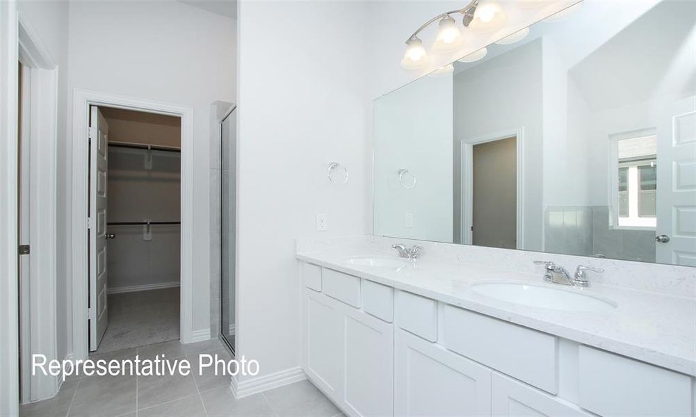 Bathroom with tile patterned flooring, vanity, and a shower with shower door