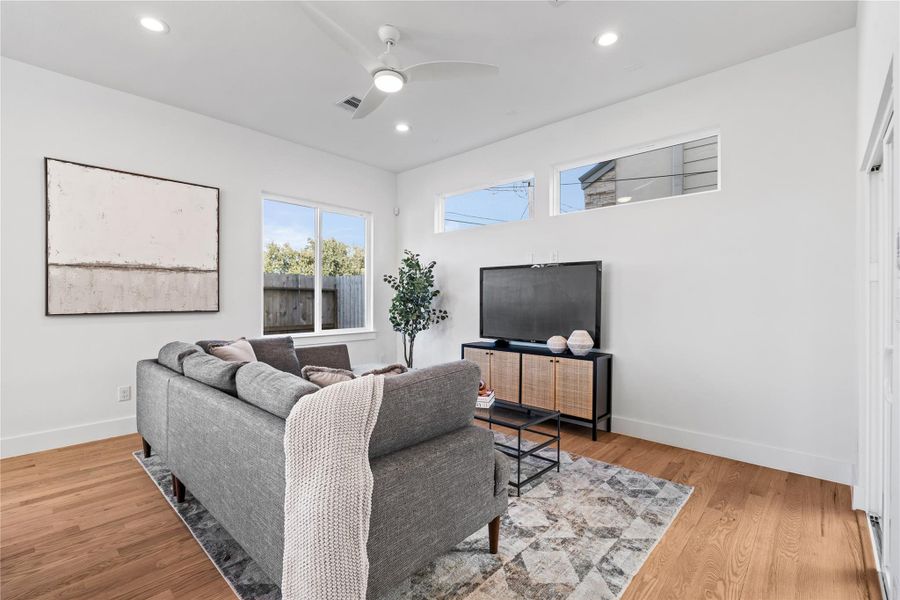Bright & inviting living room with clerestory windows, a modern ceiling fan & large sliding doors that open to the covered patio for effortless indoor-outdoor living. Bright & inviting living room with clerestory windows, a modern ceiling fan & large sliding doors that open to the covered patio for effortless indoor-outdoor living.