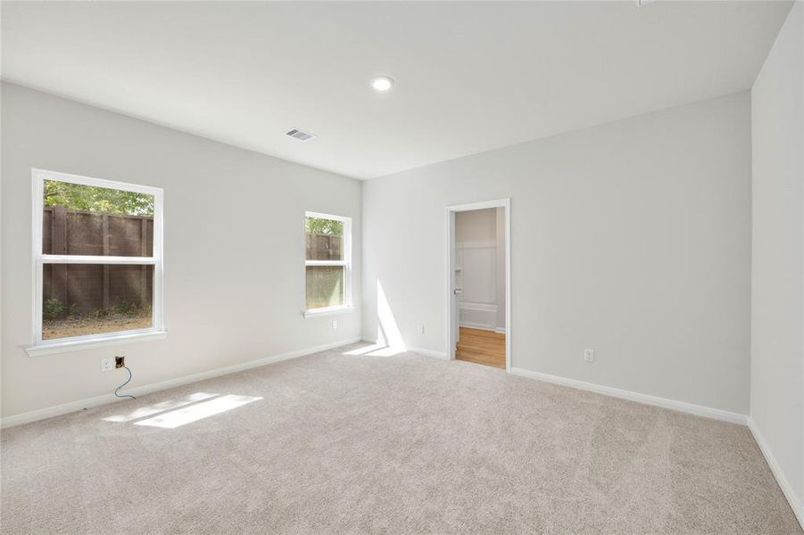 Large, primary bedroom with beautiful windows.