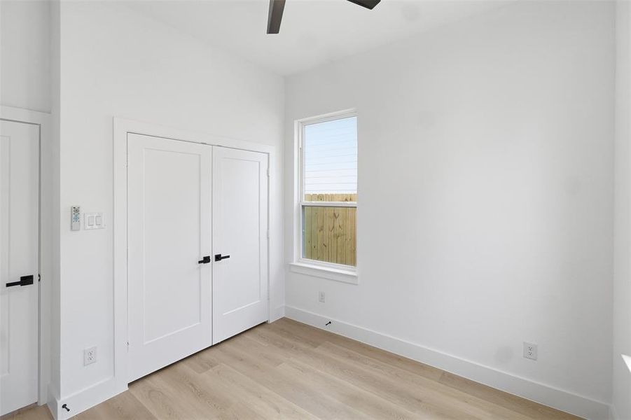 Unfurnished bedroom featuring light wood-style flooring, a closet, and a ceiling fan
