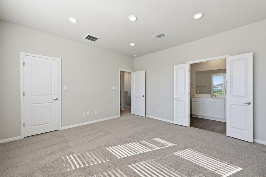 Carpeted room with recessed ceiling lighting, a neutral wall color, and white baseboards Carpeted room with recessed ceiling lighting, a neutral wall color, and white baseboards