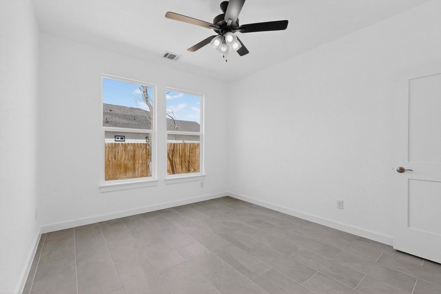 Spare room with ceiling fan and baseboards