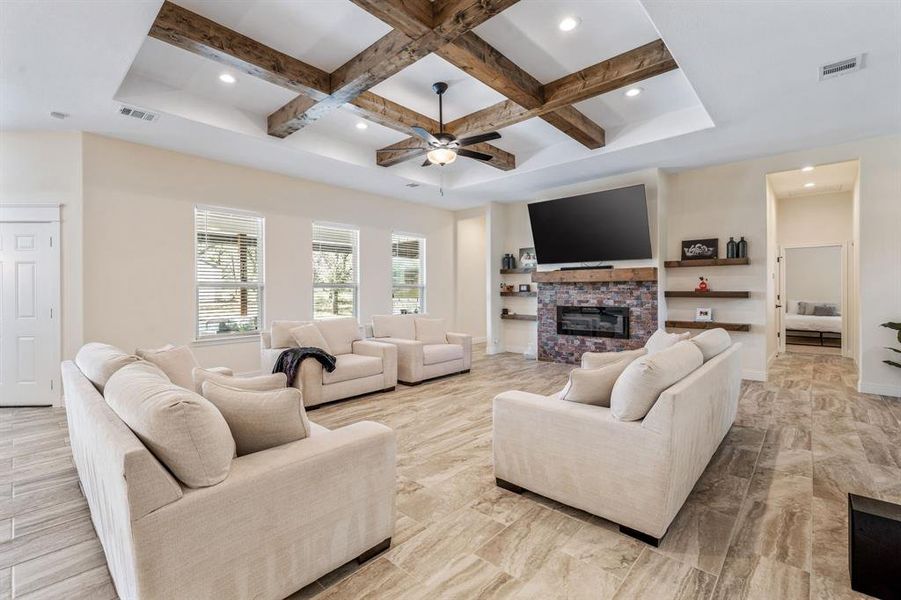 Living room featuring a stone fireplace, recessed lighting, beam ceiling, coffered ceiling, and ceiling fan Living room featuring a stone fireplace, recessed lighting, beam ceiling, coffered ceiling, and ceiling fan