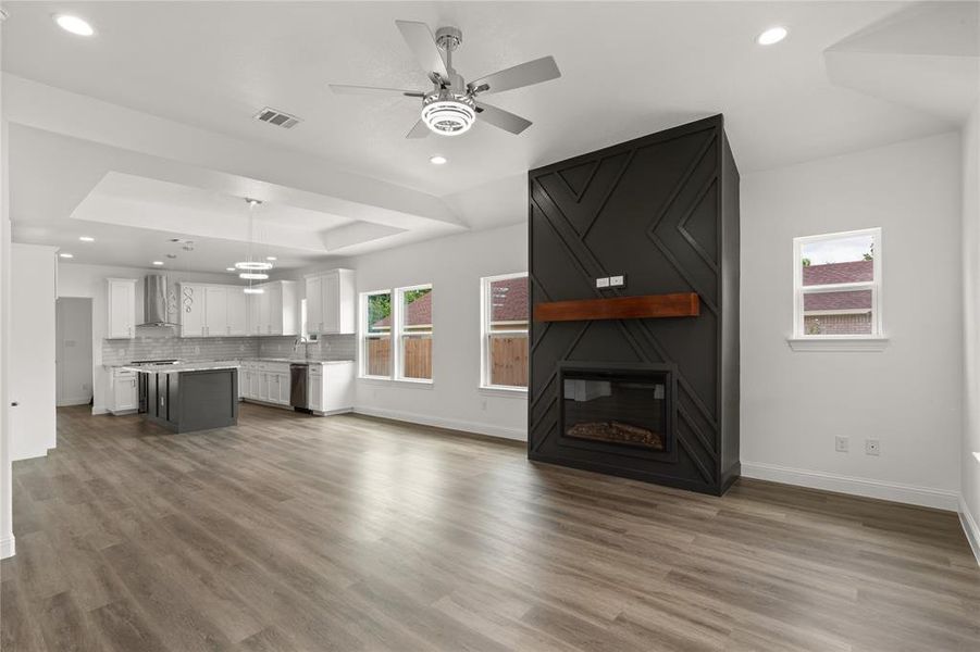 Living area featuring an electric fireplace with a dark paneled surround and a wood mantle