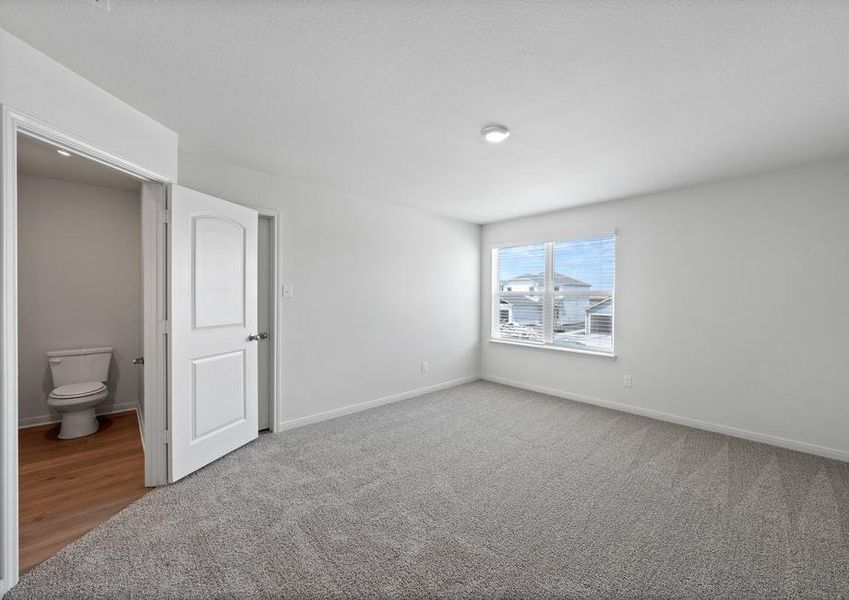 The spacious master bedroom has a large window that lets in natural light and backyard views.