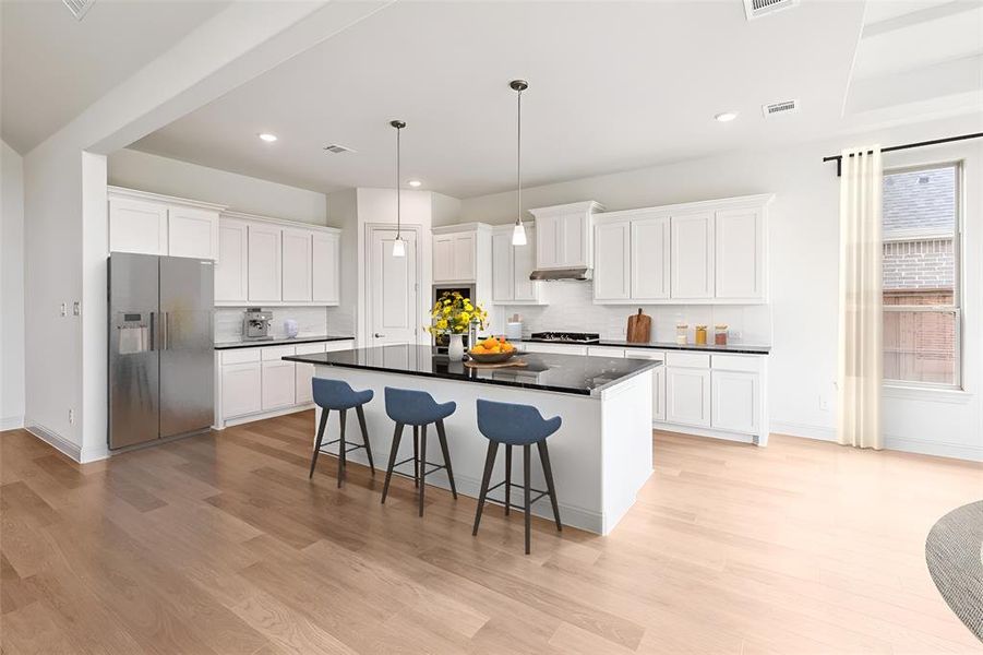 Kitchen with stainless steel refrigerator with ice dispenser, light hardwood / wood-style flooring, backsplash, and white cabinetry