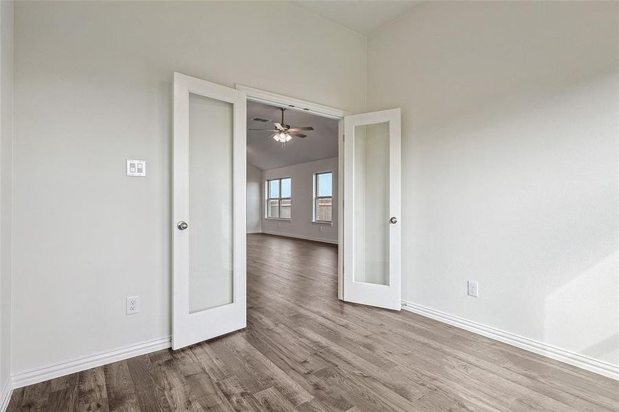 Empty room featuring light hardwood / wood-style flooring, ceiling fan, and french doors