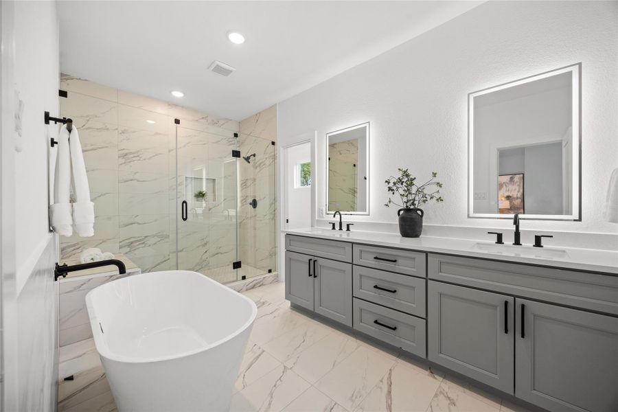 This move-in ready primary bathroom offers plenty of space to share. The stained cabinetry with light countertops and dual sinks are enhanced by the back-lit mirrors - perfect to get ready for your day! The modern tile flooring, soaking tub and oversized walk-in shower with sleek dark and modern finishes complete this gorgeous primary bathroom for a polished look. This move-in ready primary bathroom offers plenty of space to share. The stained cabinetry with light countertops and dual sinks are enhanced by the back-lit mirrors - perfect to get ready for your day! The modern tile flooring, soaking tub and oversized walk-in shower with sleek dark and modern finishes complete this gorgeous primary bathroom for a polished look.