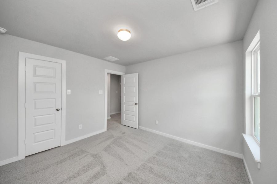 Generously sized secondary bedrooms featuring spacious closets, soft and inviting carpeting underfoot, large windows allowing plenty of natural light, and the added touch of privacy blinds for your personal retreat. Sample photo of completed home with similar floor plan. Actual colors and selections may vary.