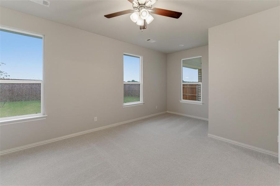 Spacious room featuring neutral carpeting and light-toned walls Spacious room featuring neutral carpeting and light-toned walls