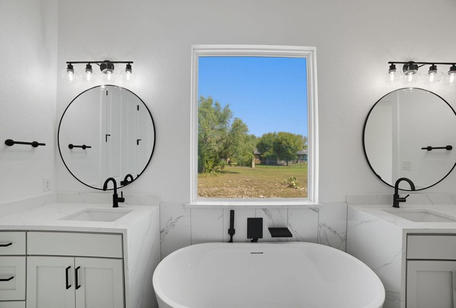 Bathroom with two vanities, a soaking tub, tile walls, and wainscoting Bathroom with two vanities, a soaking tub, tile walls, and wainscoting