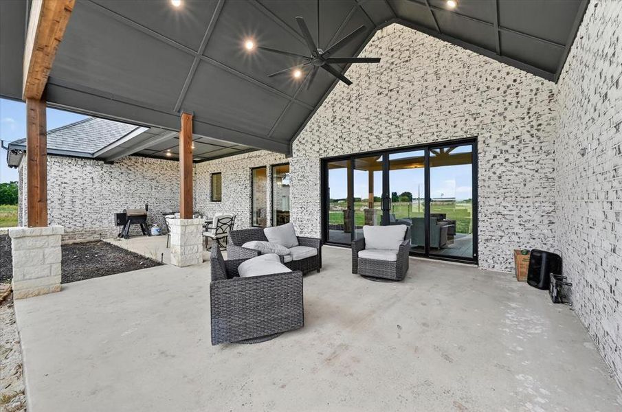 Expansive covered patio featuring a vaulted ceiling with recessed lighting and a ceiling fan