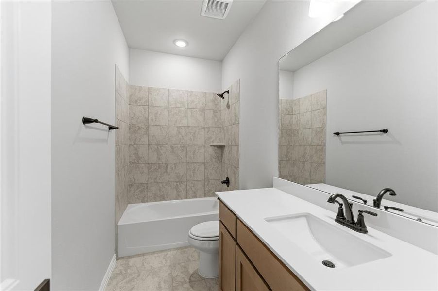 Bathroom featuring vanity, shower / washtub combination, and light marble finish flooring