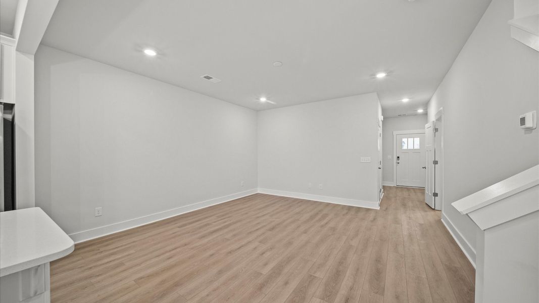 Spacious family room with rich hardwood flooring and elegant trim work in a reputable DRB Homes build