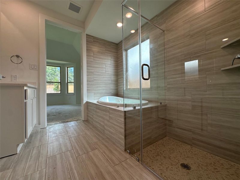 Unwind in this beautifully appointed primary bathroom, featuring a sleek glass-enclosed shower with a stylish tile floor and a luxurious drop-in tub surrounded by elegant tile. Your personal spa escape awaits! Unwind in this beautifully appointed primary bathroom, featuring a sleek glass-enclosed shower with a stylish tile floor and a luxurious drop-in tub surrounded by elegant tile. Your personal spa escape awaits!