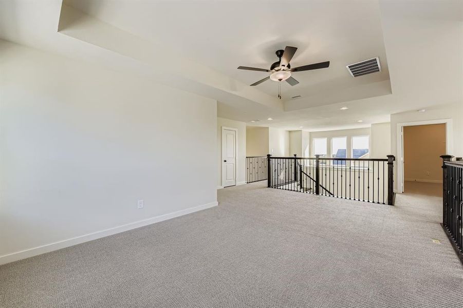 Game room featuring a tray ceiling and a ceiling fan