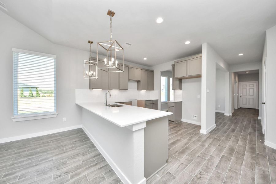 The extended counter area adds both practicality and style, making meal preparation a breeze. Every detail is thoughtfully designed to enhance the kitchen's functionality and aesthetic appeal. Sample photo of completed home with similar floor plan. Actual colors and selections may vary. The extended counter area adds both practicality and style, making meal preparation a breeze. Every detail is thoughtfully designed to enhance the kitchen's functionality and aesthetic appeal. Sample photo of completed home with similar floor plan. Actual colors and selections may vary.