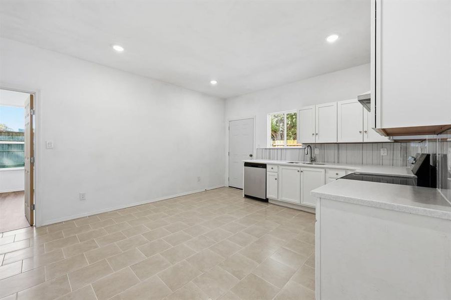 Eat-in kitchen with white cabinets, recessed lighting, stainless steel appliances, and backsplash