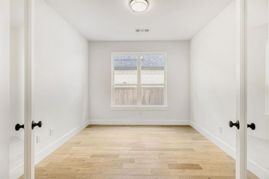 Spare room with french doors and light wood-type flooring