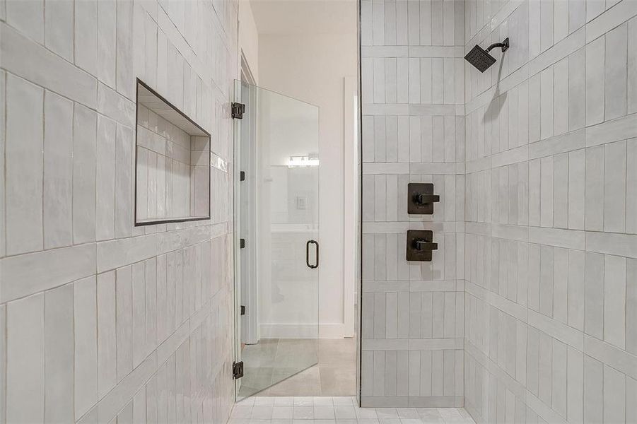 Bathroom featuring tile patterned floors and a shower with shower door