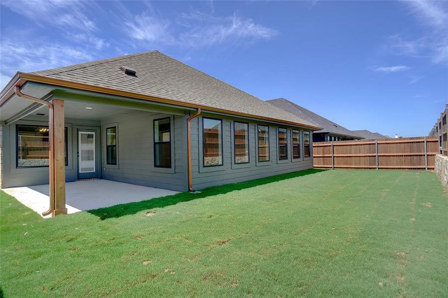 Rear view of house featuring a patio area and a lawn