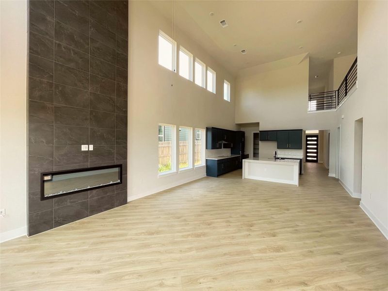 Dramatic two-story living area with soaring ceilings and an elegant tile fireplace, perfect for gatherings. Dramatic two-story living area with soaring ceilings and an elegant tile fireplace, perfect for gatherings.