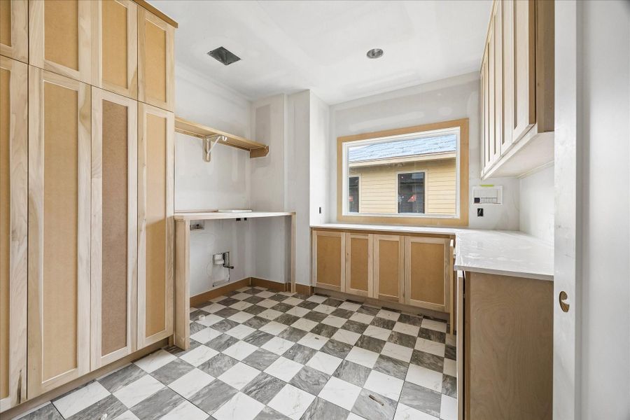 Second floor utility room designed with custom built cabinetry, open shelving, and space for a full size washer and dryer. Large window brings in natural light, making everyday tasks feel bright and organized. Second floor utility room designed with custom built cabinetry, open shelving, and space for a full size washer and dryer. Large window brings in natural light, making everyday tasks feel bright and organized.