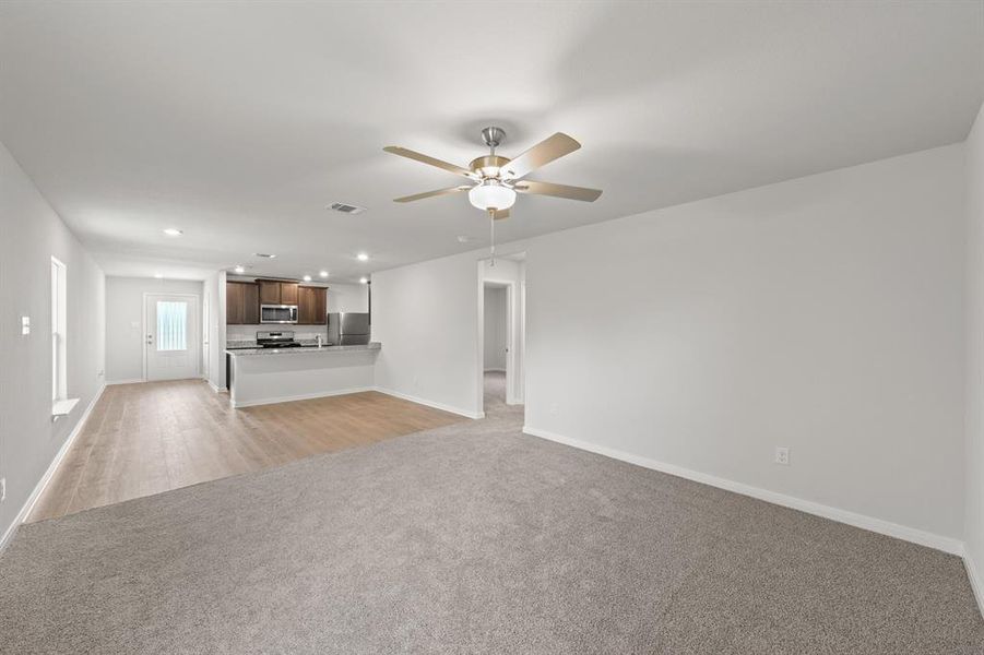 Unfurnished living room with light hardwood / wood-style floors and ceiling fan