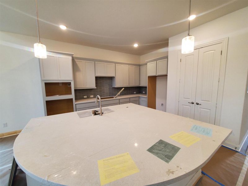 Kitchen with a kitchen island with sink and hanging light fixtures