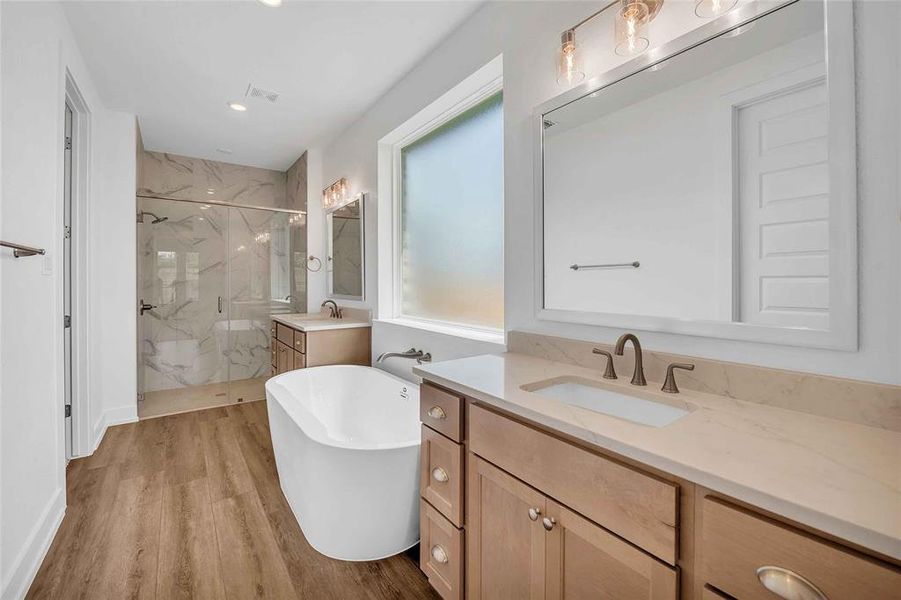Full bath featuring a sink, a marble finish shower, a soaking tub, and wood finished floors Full bath featuring a sink, a marble finish shower, a soaking tub, and wood finished floors