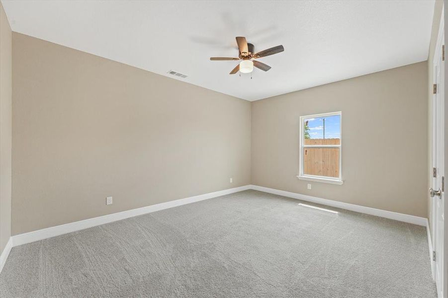 Empty room with light colored carpet and a ceiling fan Empty room with light colored carpet and a ceiling fan