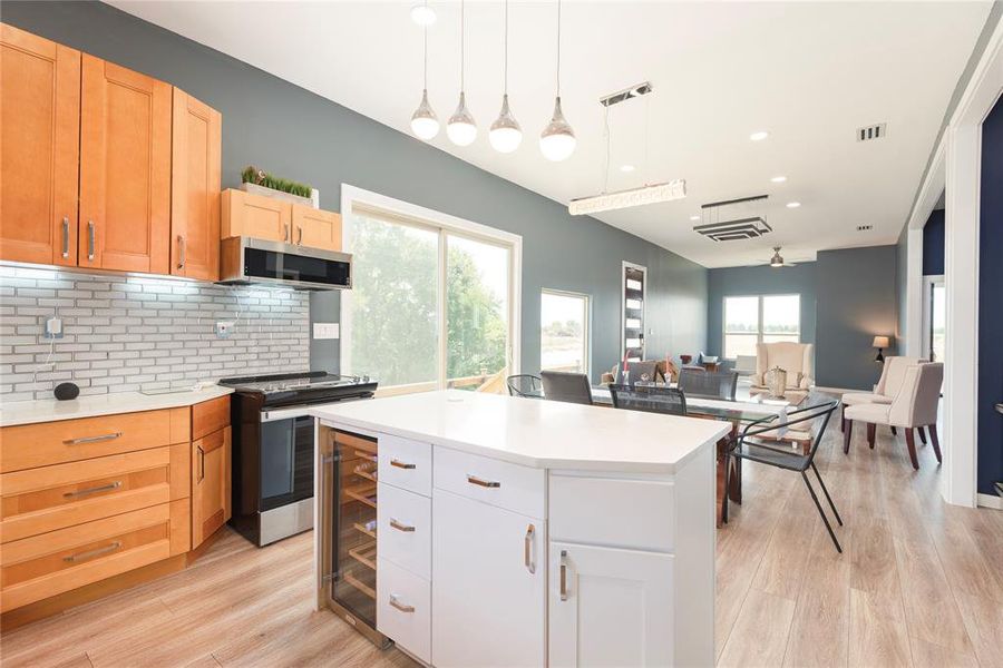 Kitchen featuring open floor plan, hanging light fixtures, decorative backsplash, healthy amount of natural light, and recessed lighting Kitchen featuring open floor plan, hanging light fixtures, decorative backsplash, healthy amount of natural light, and recessed lighting