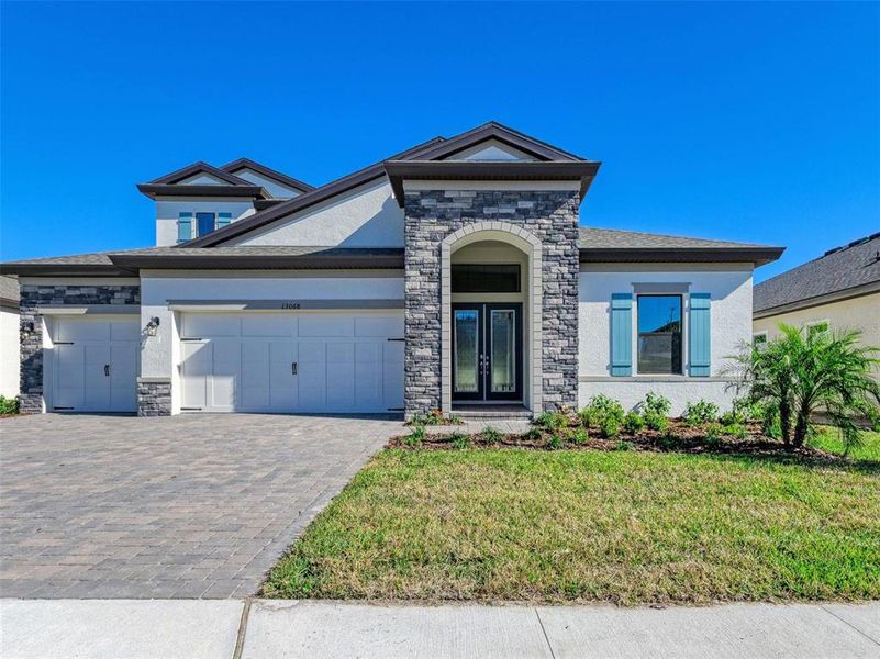 Front exterior of a new home in Crosswind Point, Parrish, FL, highlighting curb appeal (Image 1). Front exterior of a new home in Crosswind Point, Parrish, FL, highlighting curb appeal (Image 1).