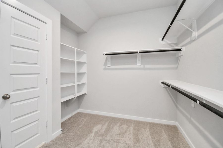Walk-in closet that epitomizes luxury and practicality. This generously sized space features built-in shelving, offering abundant room for impeccable organization. High ceilings and recessed lighting create a bright and welcoming ambiance.