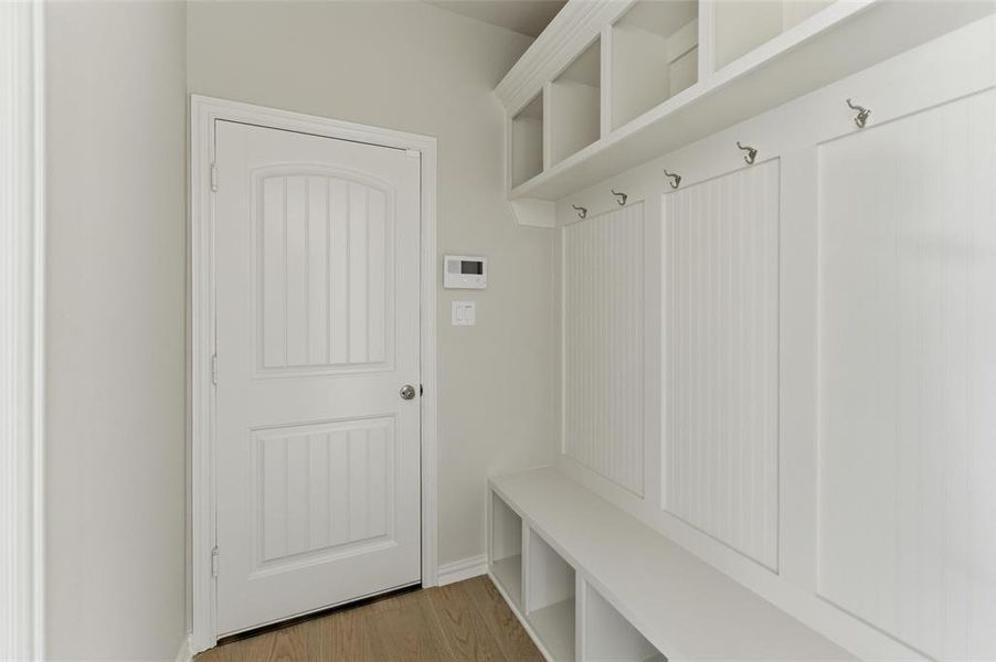 Mudroom featuring light wood-style flooring and baseboards
