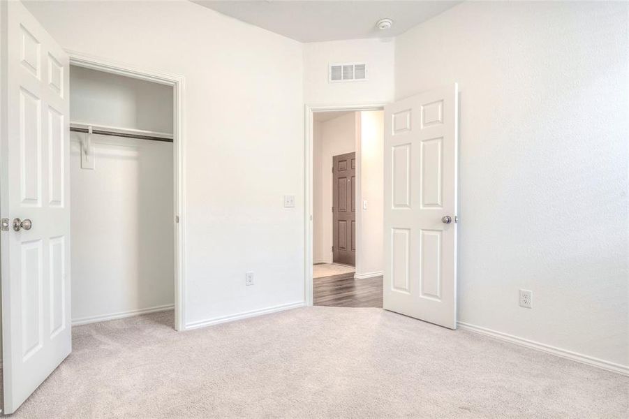 Unfurnished bedroom featuring light colored carpet and a closet Unfurnished bedroom featuring light colored carpet and a closet