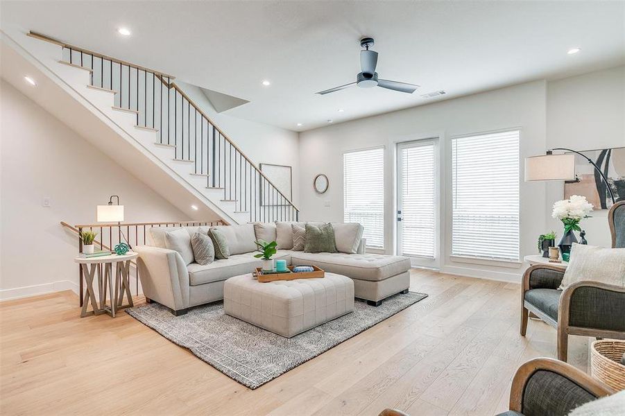 The elegant staircase, adorned with white oak hardwoods and designer railings, serves as a stunning focal point of the home.