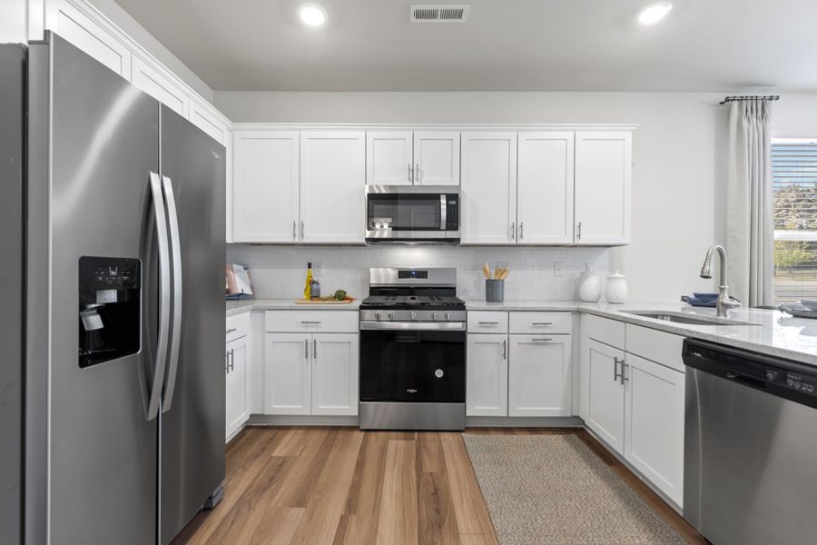 A kitchen with white cabinets.
